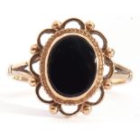 9ct gold and onyx ring, the oval shaped black onyx centre, bezel set and framed in a scrolled bead