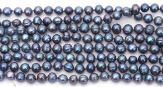 Long continuous row of dyed dark grey pearls with green and purple overtones, off round to oval