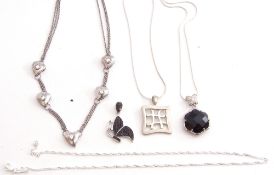 Mixed Lot: Two 925 stamped pendants on chains, each with black stone decoration, a pierced square