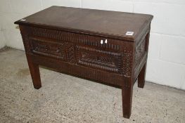 HEAVILY CARVED STORAGE CHEST WITH GEOMETRIC DECORATION TO THE LID, LENGTH APPROX 92CM, CONTAINING