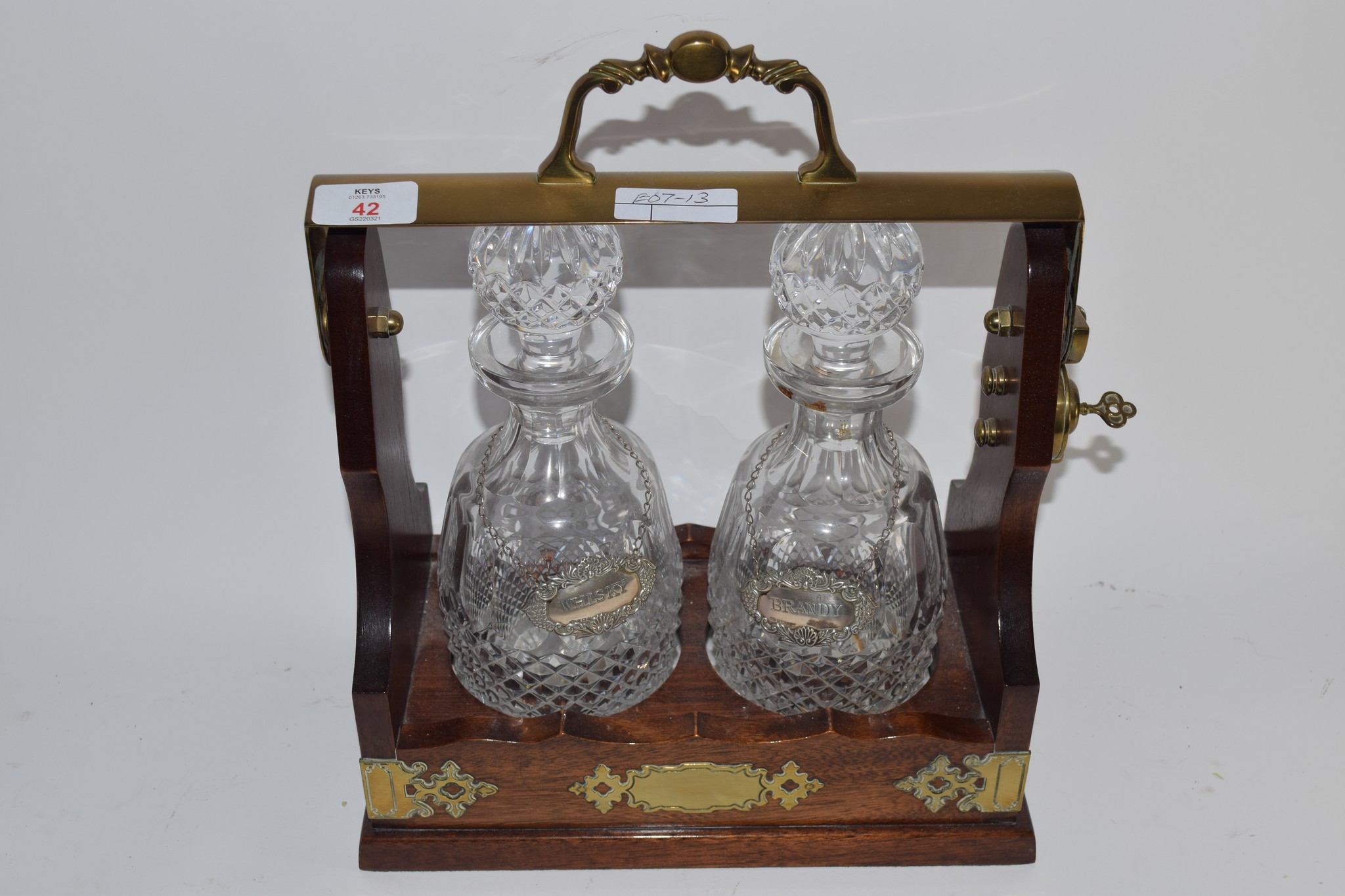 TANTALUS WITH TWO CUT GLASS DECANTERS AND SILVER PLATED LABELS WITH KEY