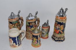 SIX POTTERY STEINS, SOME WITH METAL COVERS