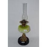 OIL LAMP ON CIRCULAR BLACK BASE WITH GLASS SHADE DECORATED IN RELIEF WITH A FLORAL PATTERN WITH