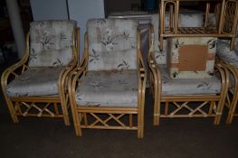 MODERN CANE CONSERVATORY SUITE COMPRISING FOUR CHAIRS, TWO-SEATER SOFA, FOOT STOOL ETC IN FLORAL