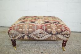 LARGE SQUARE UPHOLSTERED REPRODUCTION FOOT STOOL, APPROX 90CM SQUARE, RAISED ON TURNED LEGS ON BRASS