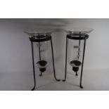 CANDLEHOLDERS WITH GLASS SHADE RAISED ON THREE METAL FEET