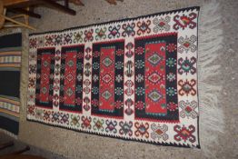 RUG WITH GEOMETRIC DESIGNS SURROUNDING FOUR SIMILARLY DECORATED PANELS, SIZE APPROX 182 X 97CM