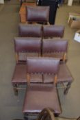 SIX EARLY 20TH CENTURY OAK DINING CHAIRS WITH RED LEATHERETTE UPHOLSTERY (ONE CARVER)