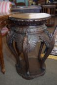 An impressive Oriental hardwood side table raised on a circular base, the legs formed as dragons