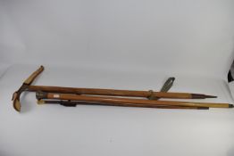 Pair of walking canes and small pickaxe, one cane with silver top, the other with a gilt metal