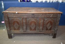 Late 17th/early 18th century oak coffer, plain plank top over a three-panelled front carved with