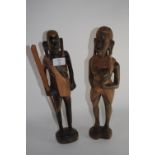 Pair of African carvings, one of a warrior holding a paddle, one of a woman, the pair 38cm high (2)