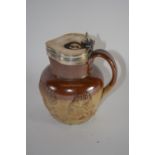 Mid-19th century pottery jug, the buff body with decoration in relief with silver rim and cover, the