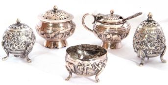 Group of five late 19th/early 20th century Indian white metal condiments, all heavily chased with