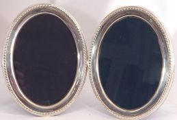 Pair of Queen Elizabeth II silver oval photograph frames, fitted with easel backs, 15cm high,