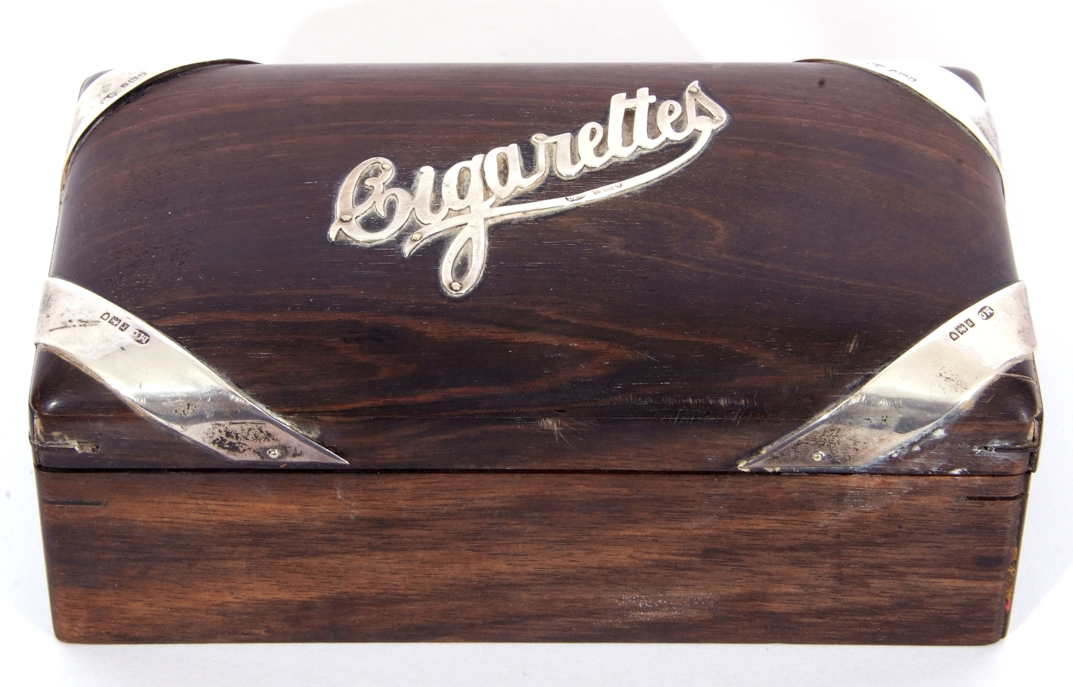 Hardwood and silver mounted table cigarette box of rectangular domed form, the centre applied with