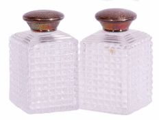 Pair of Victorian faceted cut glass scent bottles of square section with stepped tops, foliate