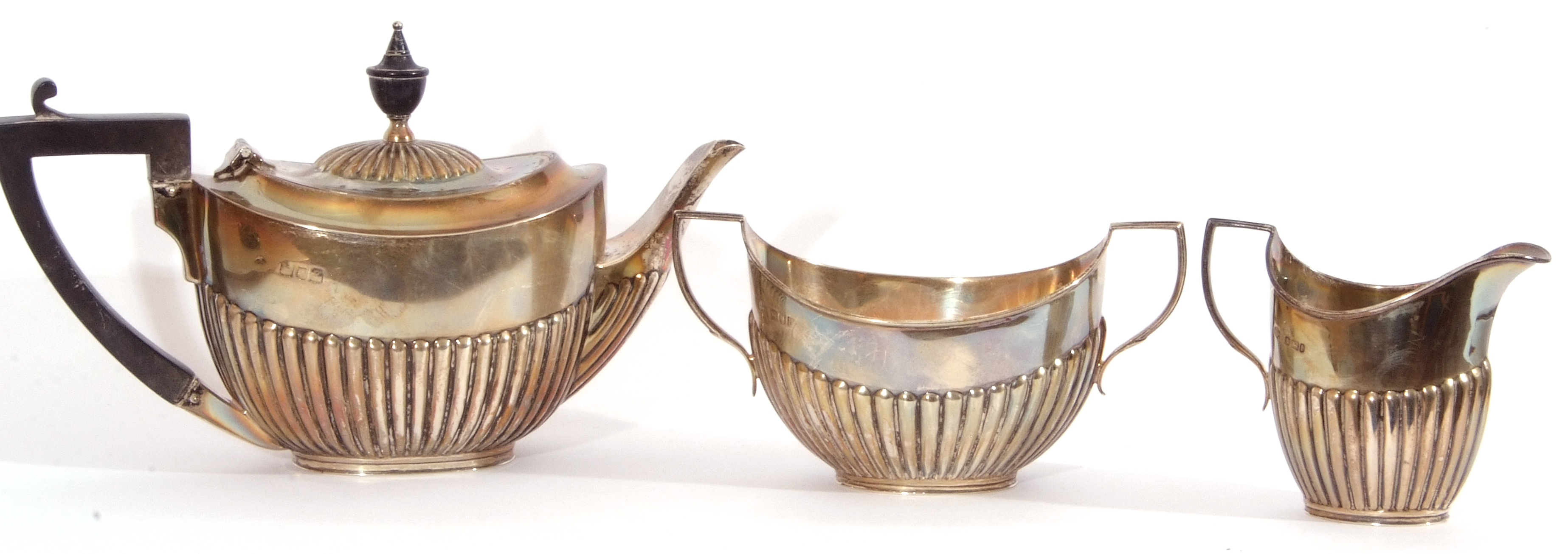 Bachelor's three piece silver tea service of oval form, half fluted bodies and angular handles,