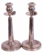 Pair of Continental white metal candlesticks, each with a baluster capital, with circular drip