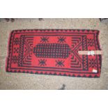 MODERN RUG WITH BLACK GEOMETRIC DESIGNS ON A RED GROUND, APPROX 128 X 62CM