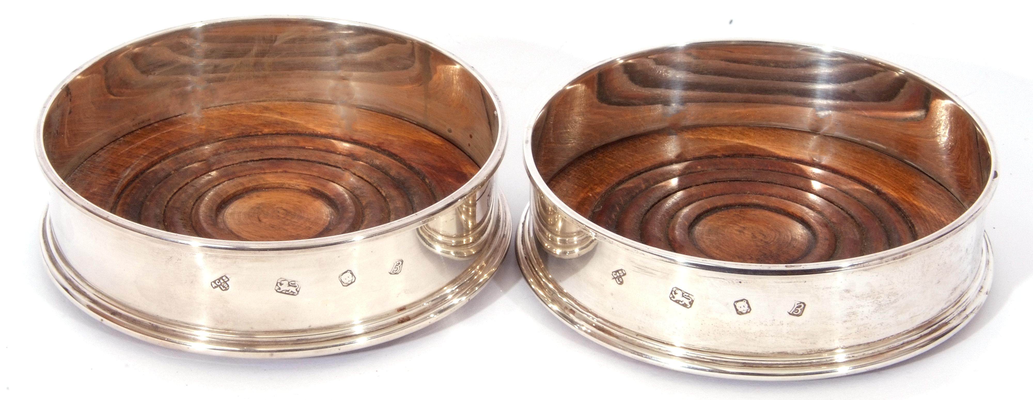 Pair of Elizabeth II silver wine coasters with plain polished sides, turned oak bases with green