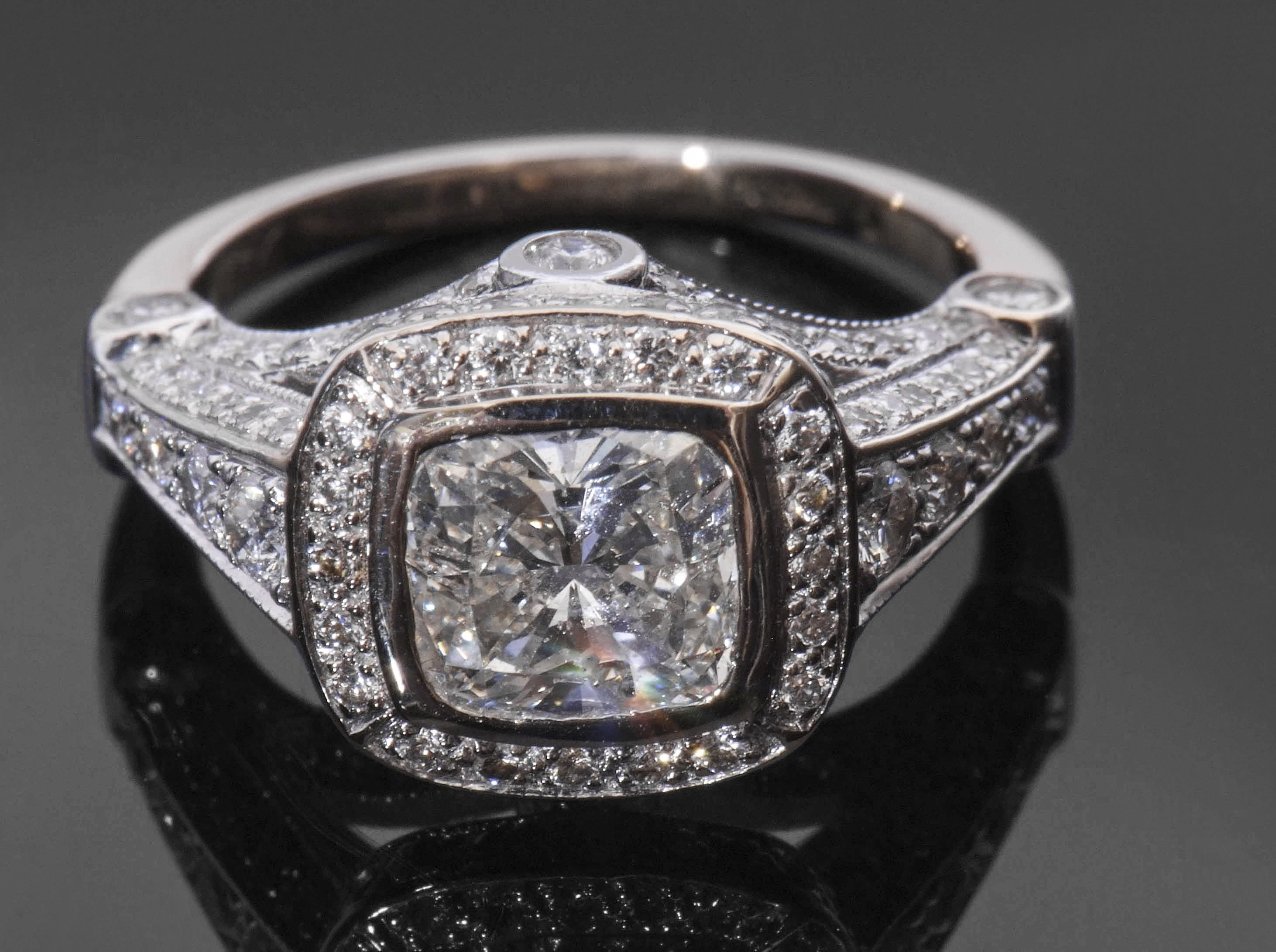 Precious metal single stone diamond ring, the cushion cut diamond weighing 1.20ct, bezel set