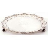 Early 20th century silver salver of shaped circular form on three leaf capped volute-scroll