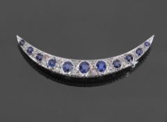 Precious metal sapphire and diamond crescent brooch, featuring 11 graduated faceted sapphires,