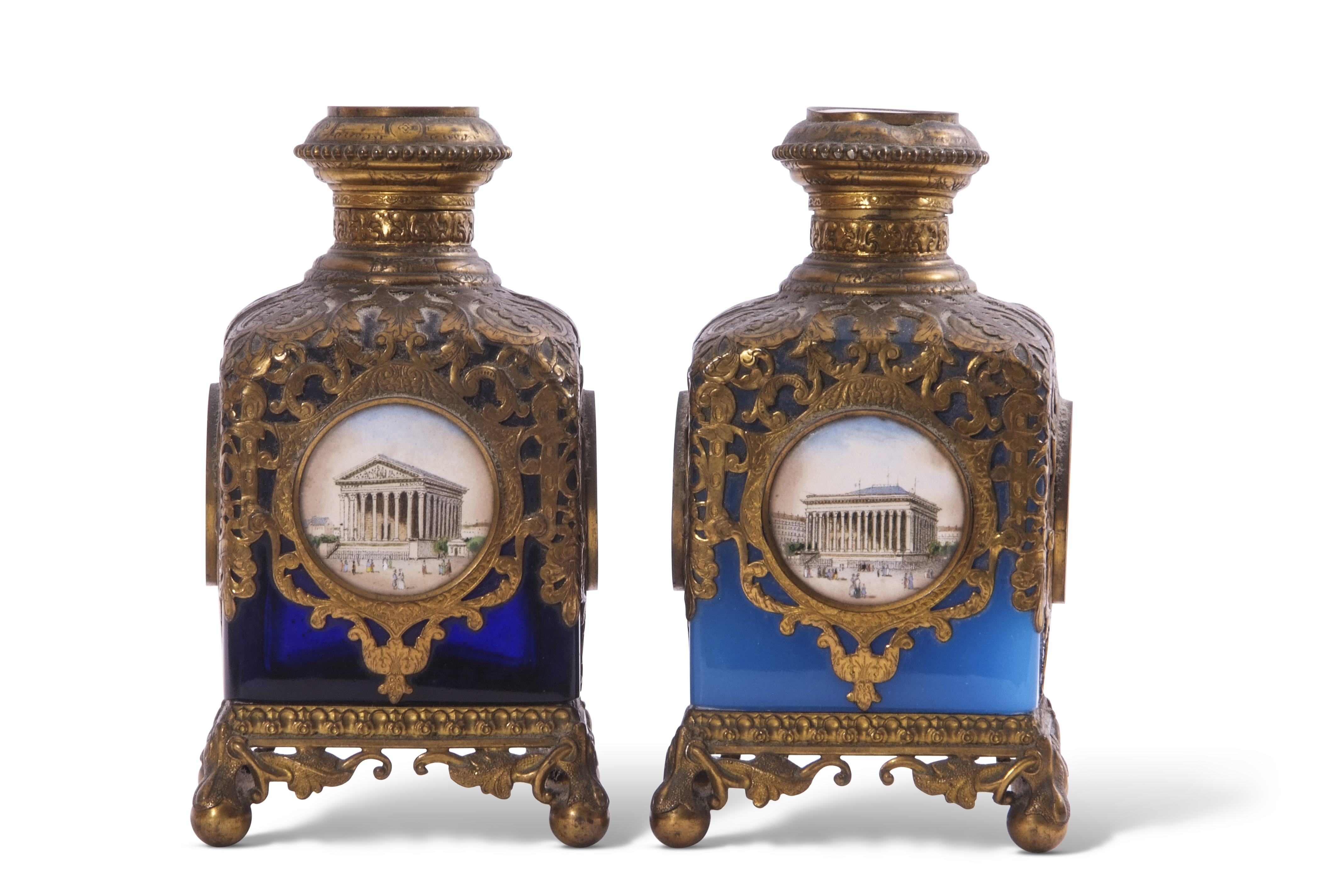 Two Palais Royale gilt metal mounted glass square scent bottles with pierced sleeves and caps