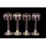 Group of four Bohemian goblets, the bowls flashed with a purple design above a faceted stem with