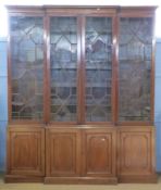 19th century mahogany break front bookcase featuring a swept cornice with carved dentil detail above