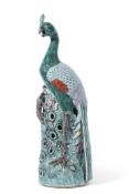 An impressive Chinese porcelain model of a peacock in famille vert palette on circular base, 60cm