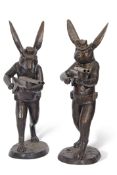 Large contemporary pair of bronze hares wearing hats, rucksacks and cartridge belts and each holding