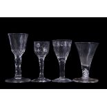 Group of four 18th century glasses, one with firing foot, one with faceted stem and engraved