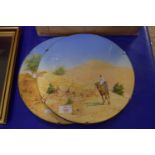 PAIR OF CIRCULAR GLASS STANDS WITH PRINTS OF MIDDLE EAST DESERT SCENES