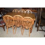 MODERN STAINED PINE RECTANGULAR DINING TABLE AND A SET OF SIX WHEEL BACK CHAIRS, THE TABLE APPROX