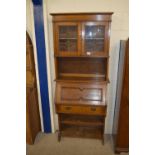 OAK FALL FRONT BUREAU BOOKCASE WITH ASTRAGAL GLAZED CUPBOARD ABOVE IN THE ARTS AND CRAFTS STYLE,