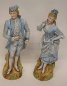 Late 19th century Continental figures of a gentleman and lady in bisque porcelain, painted in