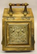 Late 19th century brass coal scuttle with wooden handle, the front decorated with scrolling