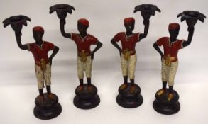 Four candle holders modelled as Moors on circular bases