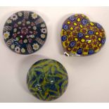 Three glass paperweights, one heart shaped with predominantly blue and yellow cones, the others with