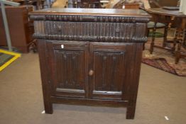 Oak side cabinet of panelled construction, with carved linenfold doors and carved frieze
