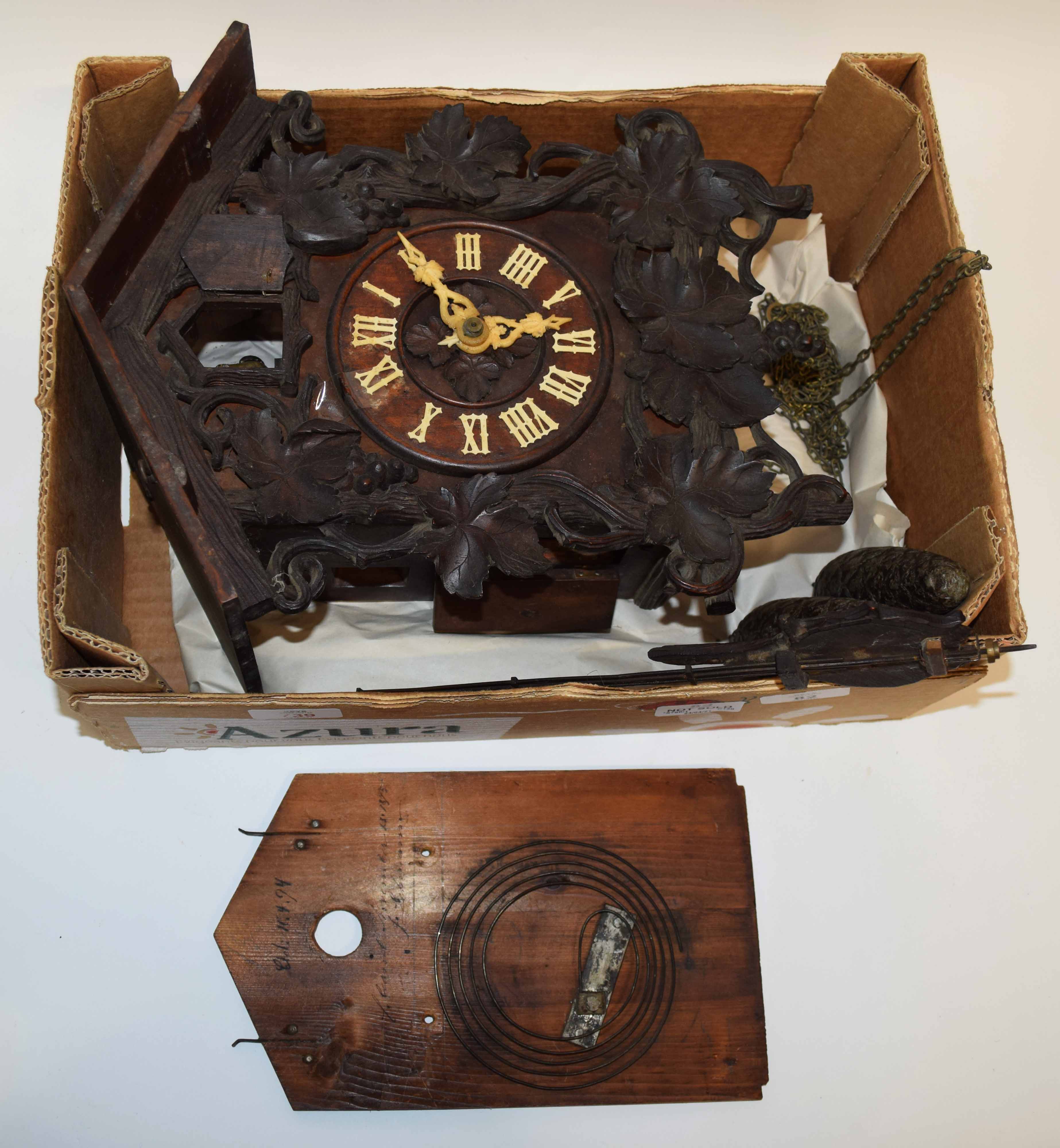 Black Forest cuckoo clock decorated with leaves and grapes with cone shaped weights with the hands