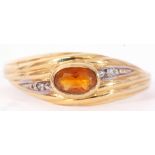 Modern 750 stamped citrine and diamond set ring centring an oval faceted cognac citrine in a rub-