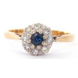 Sapphire and diamond cluster ring, the round faceted cut sapphire raised above a small diamond