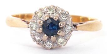 Sapphire and diamond cluster ring, the round faceted cut sapphire raised above a small diamond