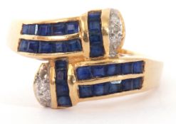 Modern sapphire and diamond cross over ring, each shoulder with 14 small calibre cut sapphires, pave