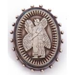 Antique white metal oval brooch, the centre applied with a chased and engraved winged figure in an