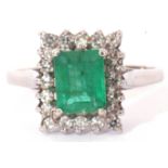 Precious metal emerald and diamond ring, centring a step cut emerald, 6mm x 4mm, raised within a