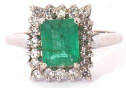Precious metal emerald and diamond ring, centring a step cut emerald, 6mm x 4mm, raised within a